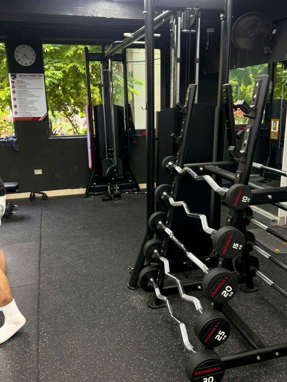 Giá để tạ đòn cong nhiều mức cân nặng bên cạnh bảng nội quy